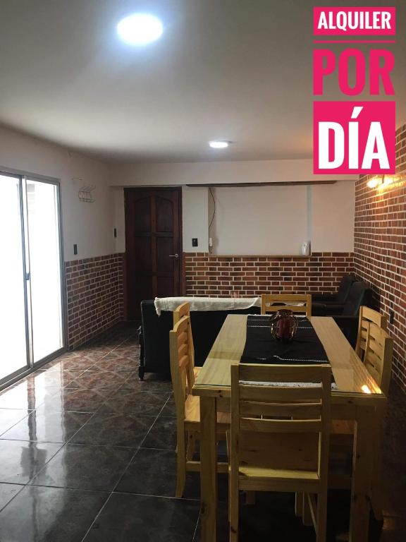 un comedor con mesa y sillas en una habitación en Casa por día en Olavarría