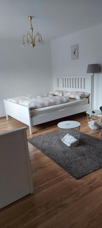 una camera bianca con un letto e un tappeto di Kleines Schmuckstück a Ermstedt