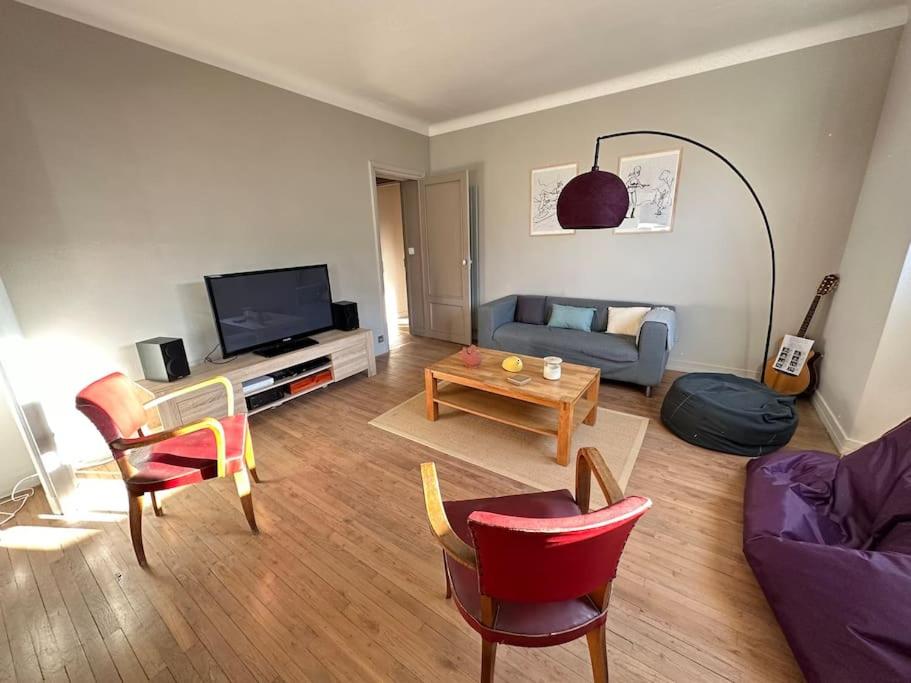 a living room with a couch and a tv at Appartement de charme - Lorient in Lorient