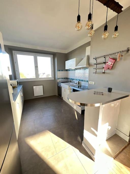 a kitchen with a large island in the middle at Appartement de charme - Lorient in Lorient