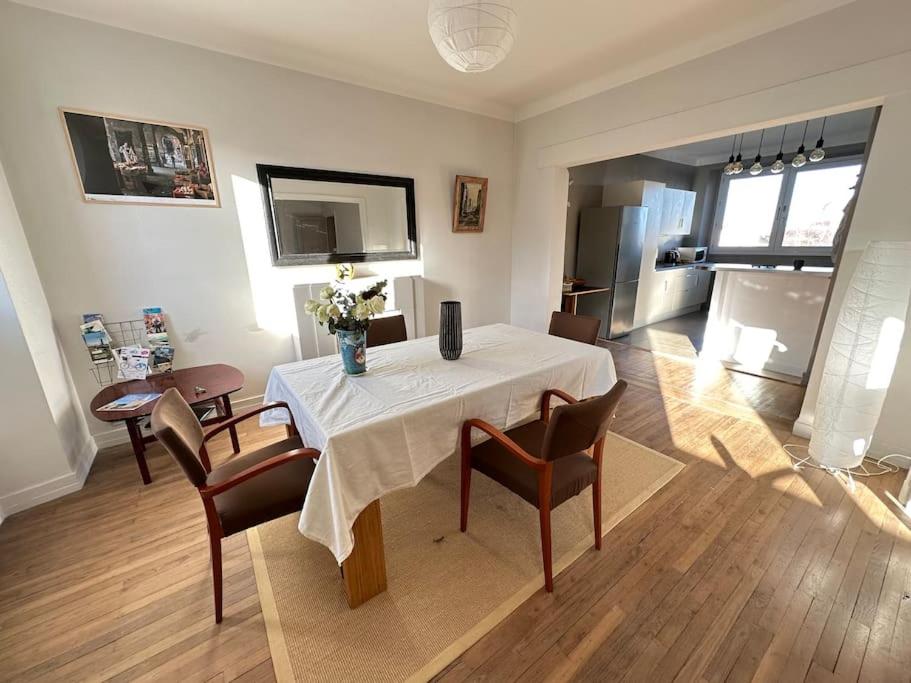 a living room with a table and chairs and a kitchen at Appartement de charme - Lorient in Lorient
