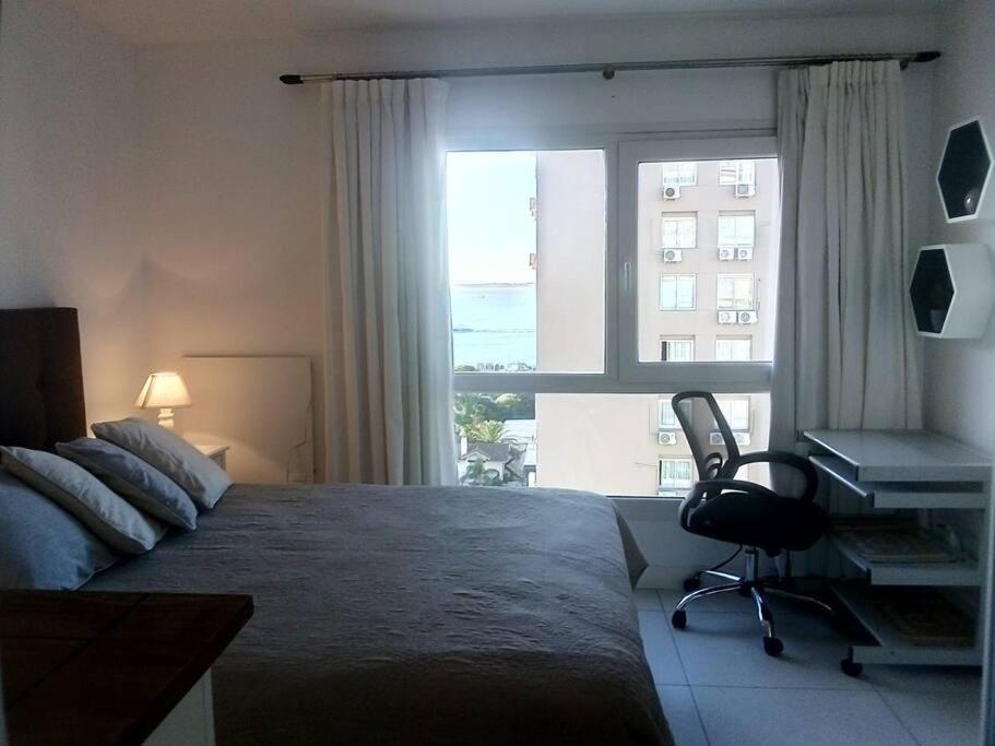 1 dormitorio con cama, escritorio y ventana en Lux Tower Departamento 2 ambientes para 2 a 4 personas, en Punta del Este