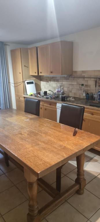 a kitchen with a wooden table with two chairs at Hote du Lion in Saint-Genis-Pouilly