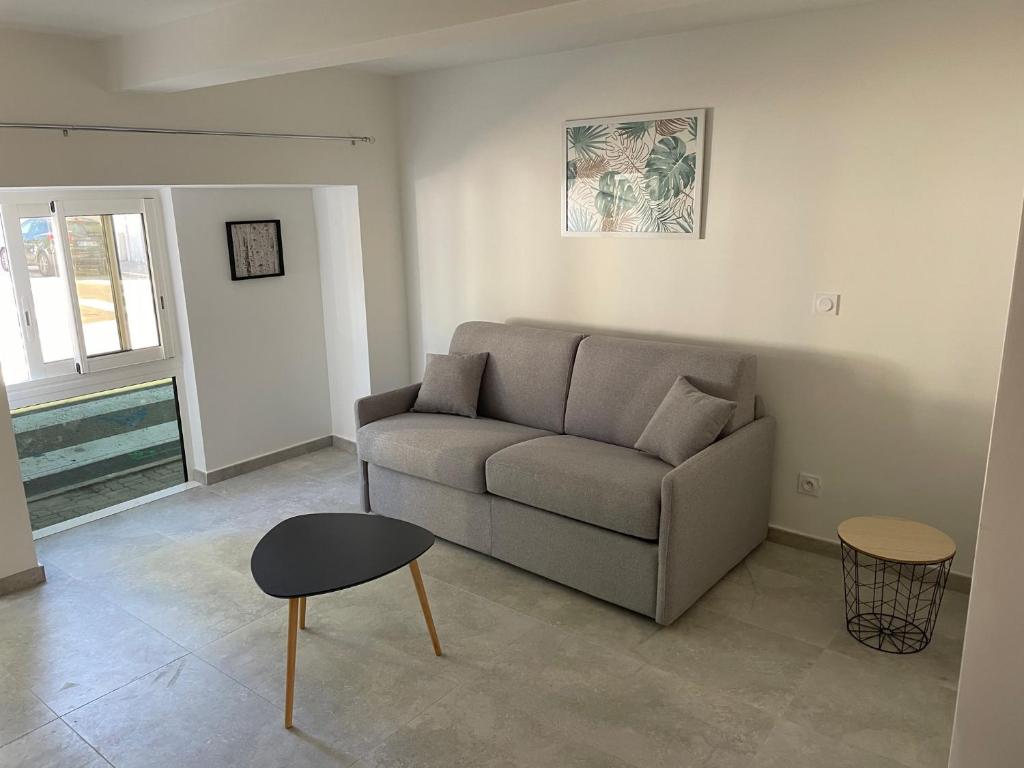 uma sala de estar com um sofá e uma mesa em Studio avec terrasse au calme Centre ville - NEG1 em Cannes