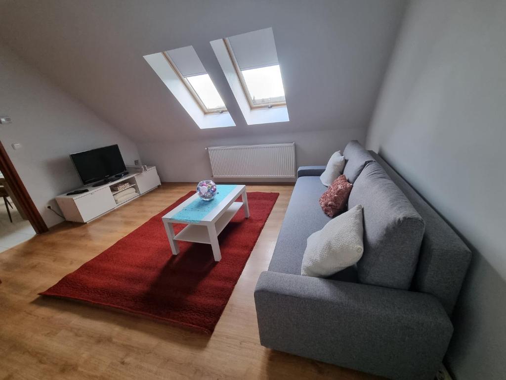 sala de estar con sofá y mesa en Bohém Apartman, en Nyergesújfalu