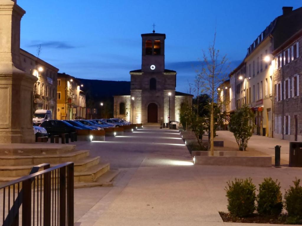 a building with a clock tower in the middle of a street at Appartement confortable centre du village in Pélussin