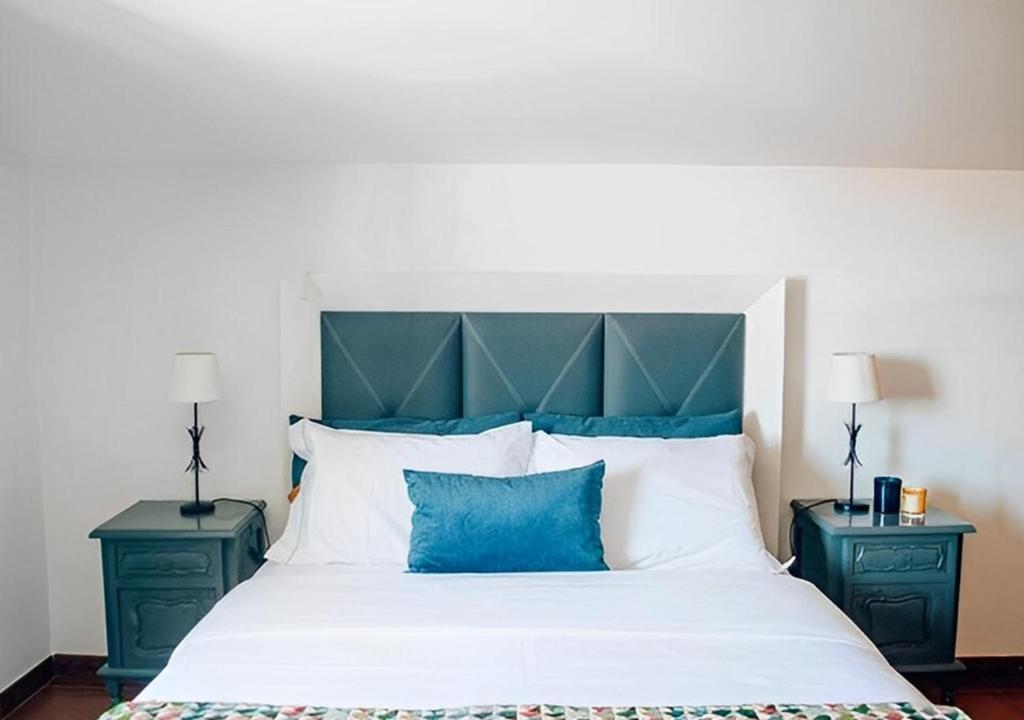 um quarto com uma cama grande e almofadas azuis e brancas em Casa Bela Vista de Moledo em Moledo