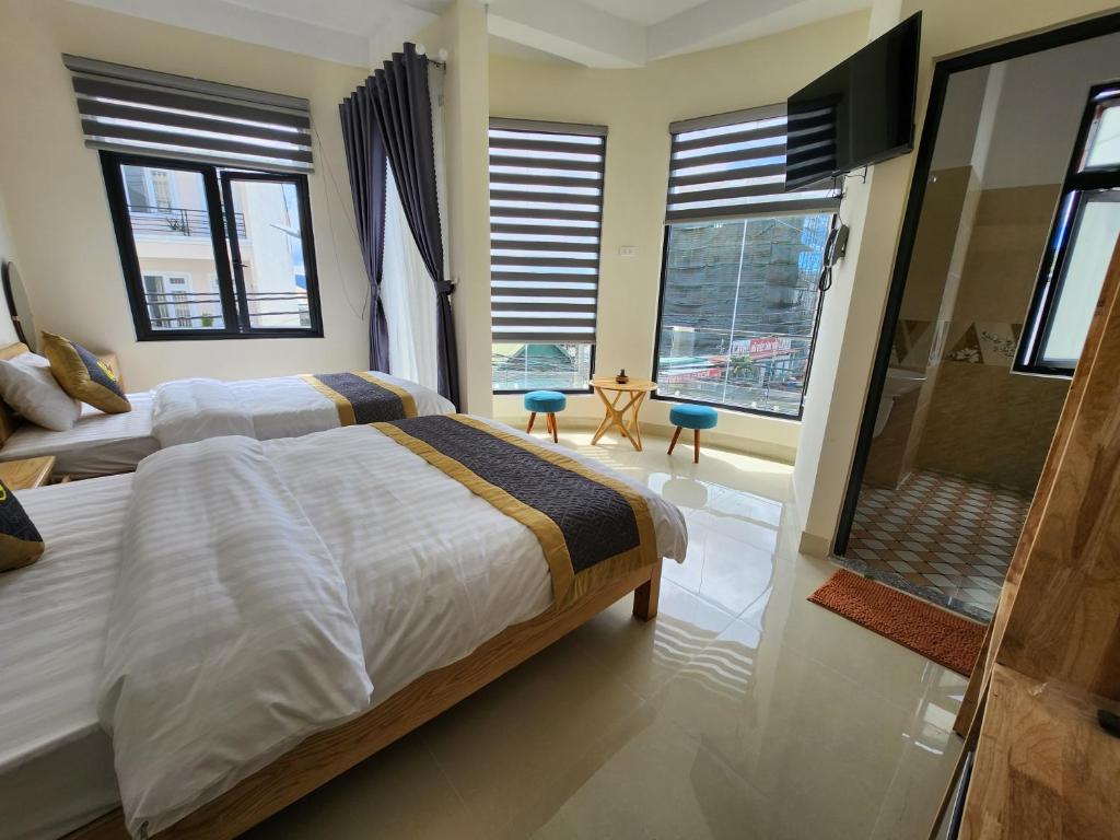 um quarto com uma cama grande e janelas grandes em K Bình Phương Hotel em Da Lat