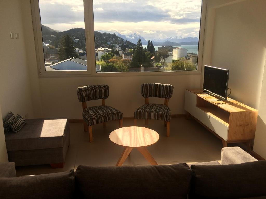 - un salon avec un canapé, une table et une fenêtre dans l'établissement Amanecer en el Lago, à San Carlos de Bariloche