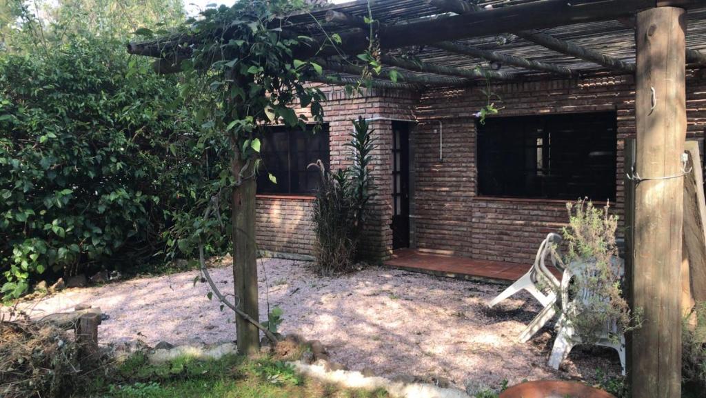 a patio with a chair and a brick house at Casa ideal para pareja en Bella Vista - Maldonado in Bella Vista