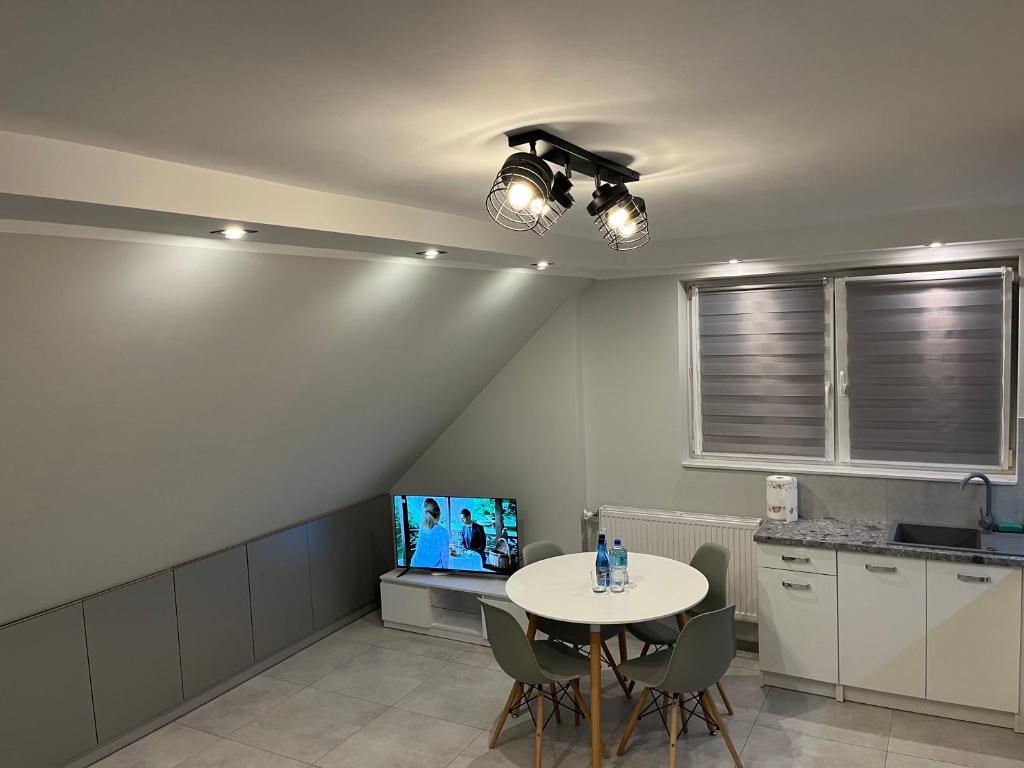 a dining room with a table and a tv at Apartament, noclegi na doby - Raczki k. Suwałk in Raczki