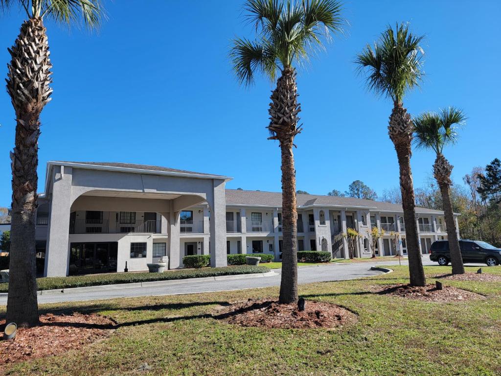 a building with palm trees in front of it at Inn at Mulberry Grove in Port Wentworth