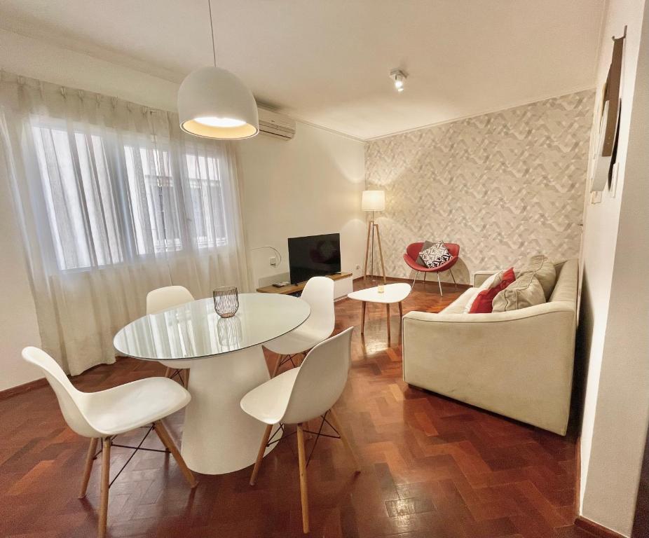 sala de estar con mesa, sillas y sofá en Mdz Apartments en Mendoza