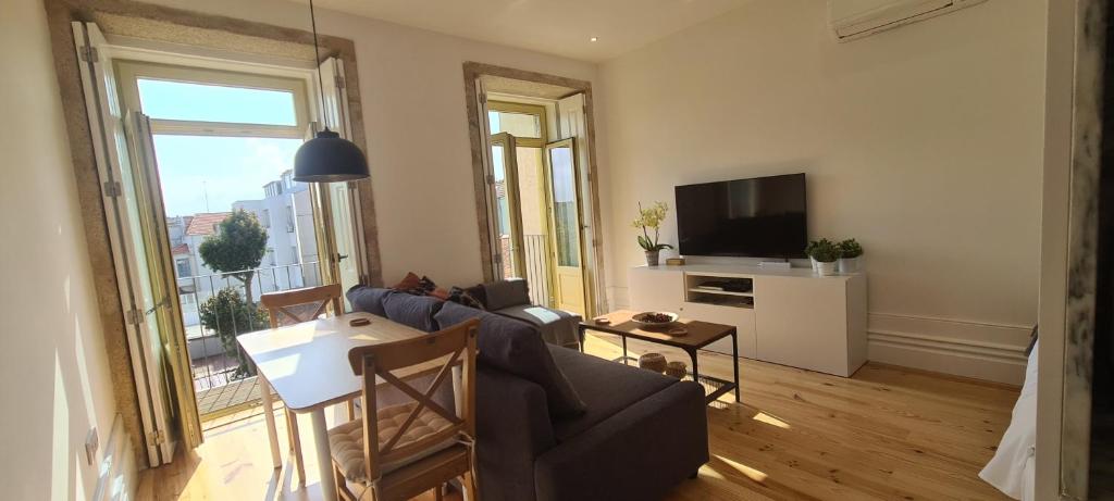 - un salon avec un canapé et une télévision dans l'établissement Merc Porto Estudio 245, à Porto