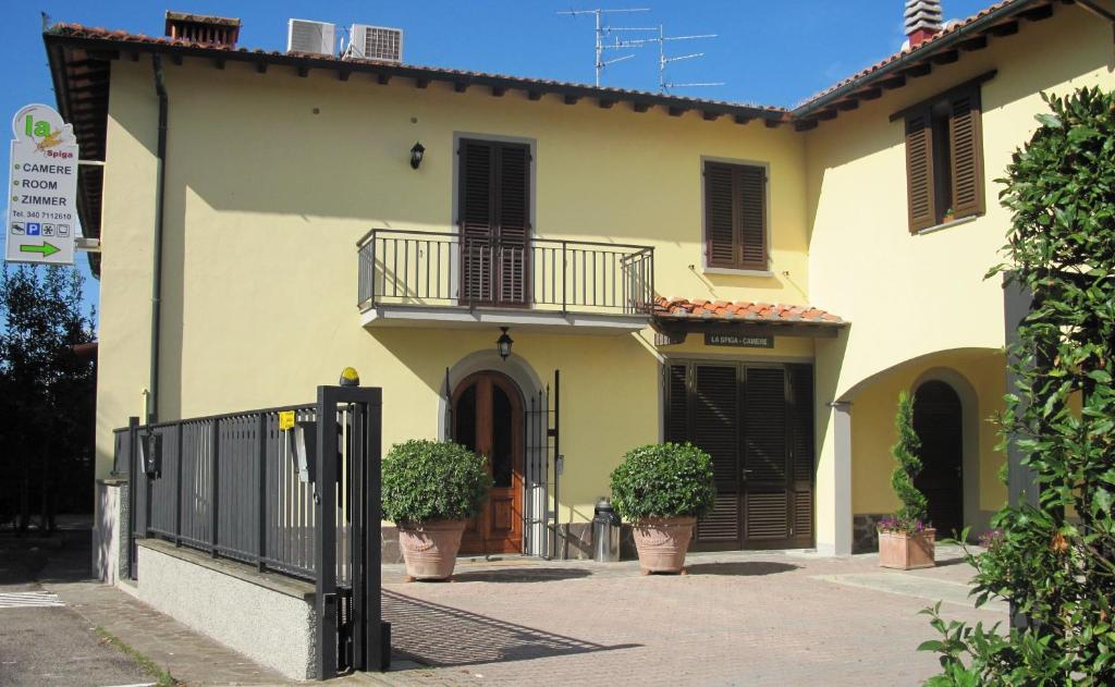 une maison avec deux plantes en pot devant elle dans l'établissement La Spiga, à Campi Bisenzio