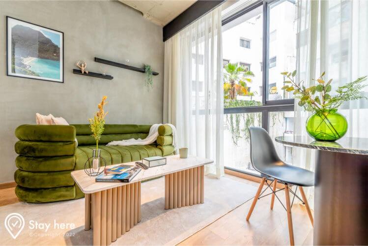 a living room with a green couch and a table at Stayhere Casablanca - Gauthier 1 - Modern Residence in Casablanca