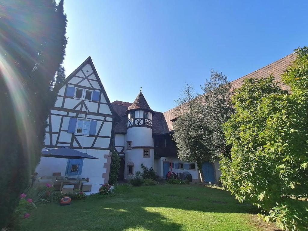 a large white and black house with a yard at Maison Kobold XVIè siècle in Wissembourg