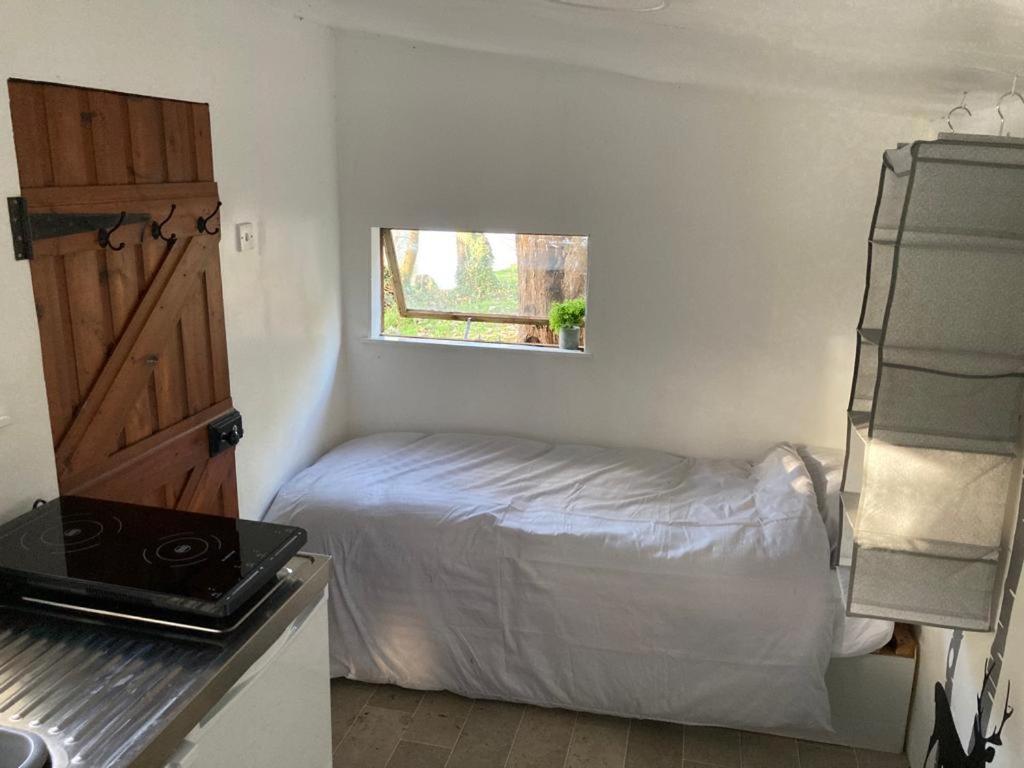 a small bedroom with a bed and a window at Fisherman's Cabin on the banks of the River Meon in Southampton