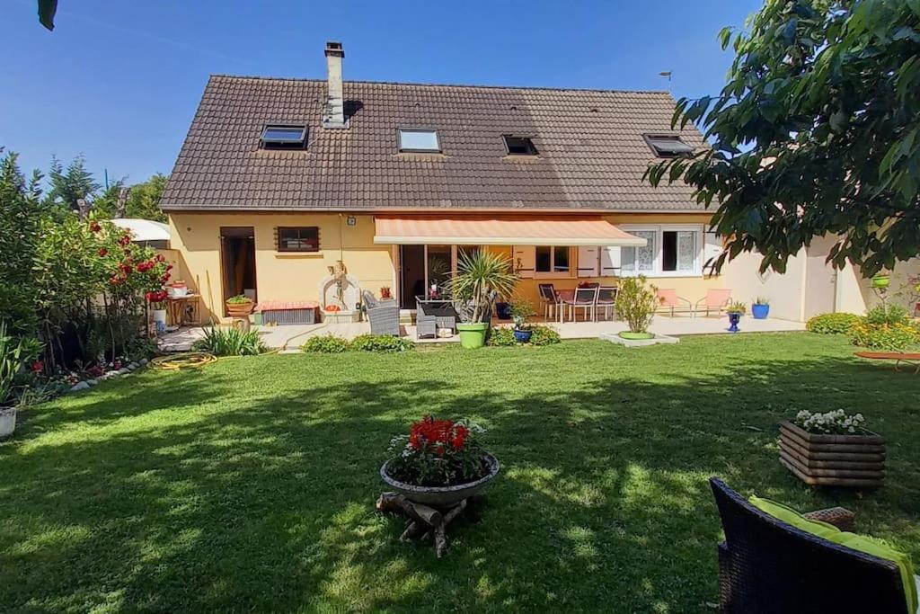 uma casa com um vaso de flores no quintal em proche Paris maison dans village près de reims 