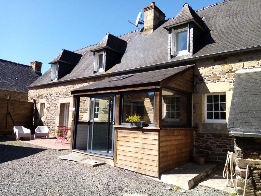 maison bretonne,gîte de keranglaz في Ploubezre: تمديد إلى منزل مع باب زجاجي منزلق