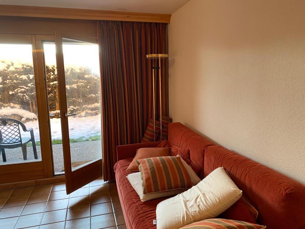 a couch in a living room with a window at Garden Studio Apartment Crans Montana in Crans-Montana