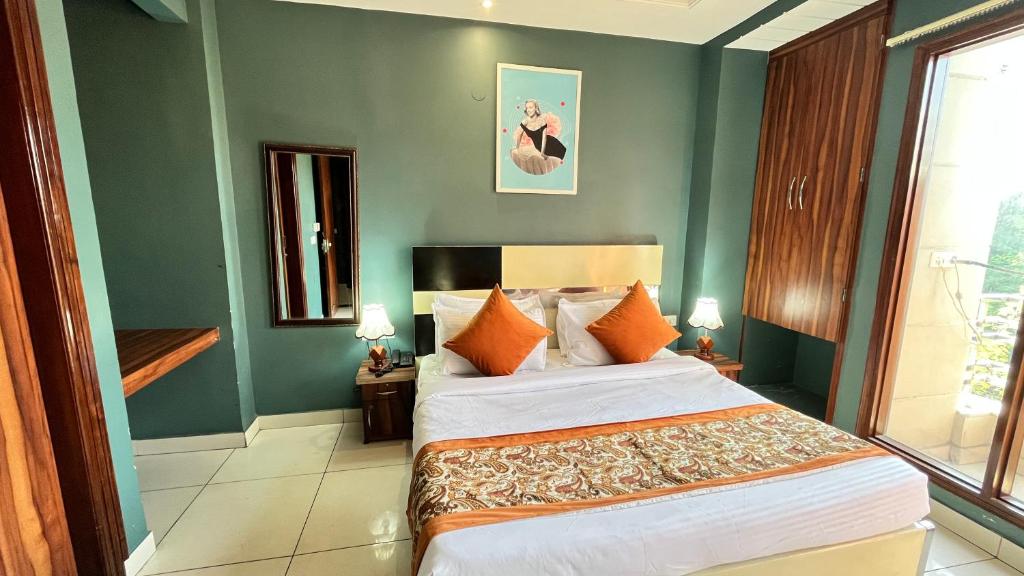 - une chambre avec un grand lit et des oreillers orange dans l'établissement Qotel Hotel Church House Rohini Sector 15- Couple Freindly, à New Delhi