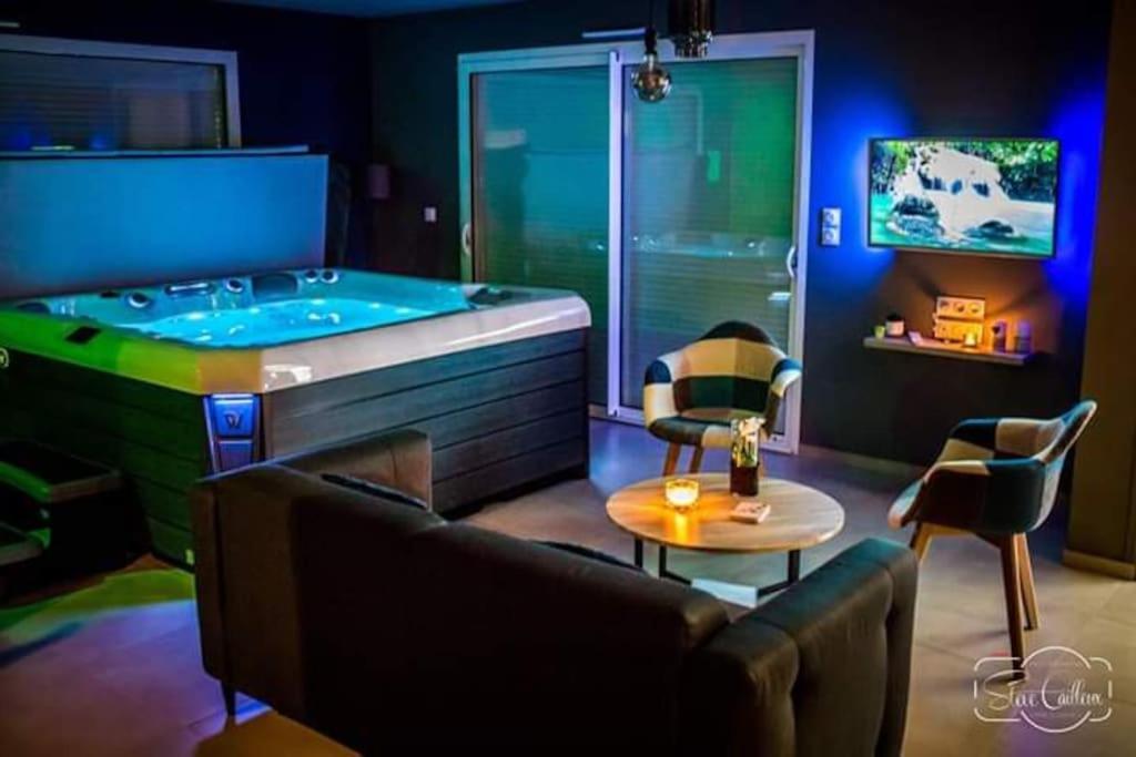 a living room with a tub with chairs and a table at Le NaturOspa in Le Quesnoy-en-Artois