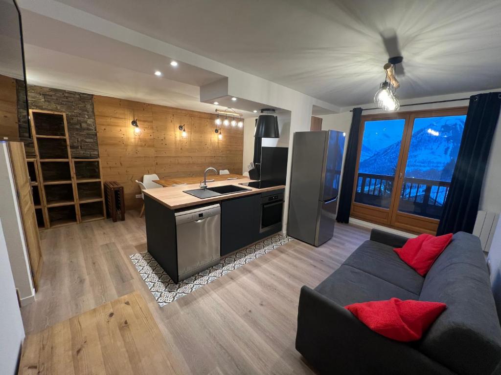 un soggiorno con divano e una cucina di Duplex 12p St Sorlin D'arves résidence Odalys a Saint-Sorlin-dʼArves