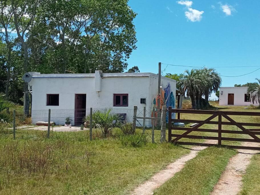 Casa rural cerca del Cabo في Rincón de los Oliveras: بيت ابيض امامه سياج
