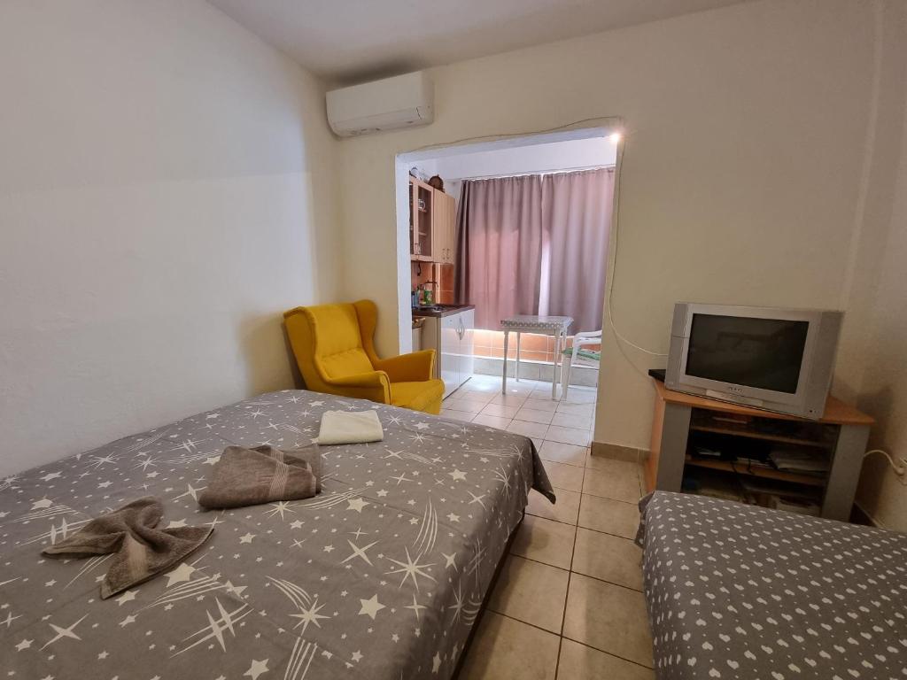 a bedroom with a bed and a tv and a chair at Kamenovo sea in Budva