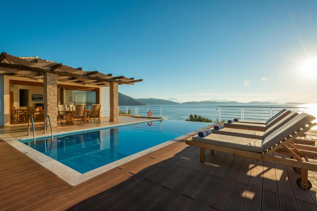 een villa met een zwembad en een huis bij Iris Villas Lefkada - Karavi Villa in Évyiros