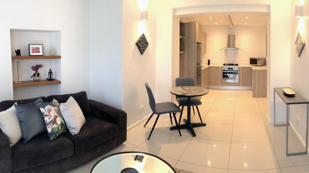 uma sala de estar com um sofá e uma mesa em Villa 17 - Spacious Apartment in Green Point na Cidade do Cabo