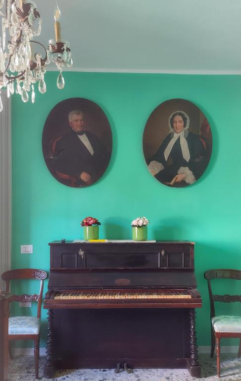 um piano numa sala com duas fotografias na parede em Art action room 