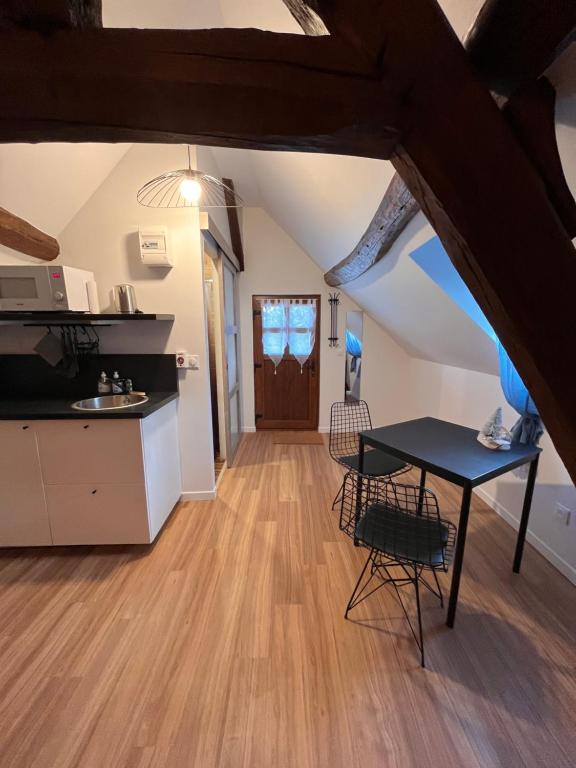a kitchen and a dining room with a table and chairs at Cozy loft in Normandy in Saint-Gâtien-des-Bois