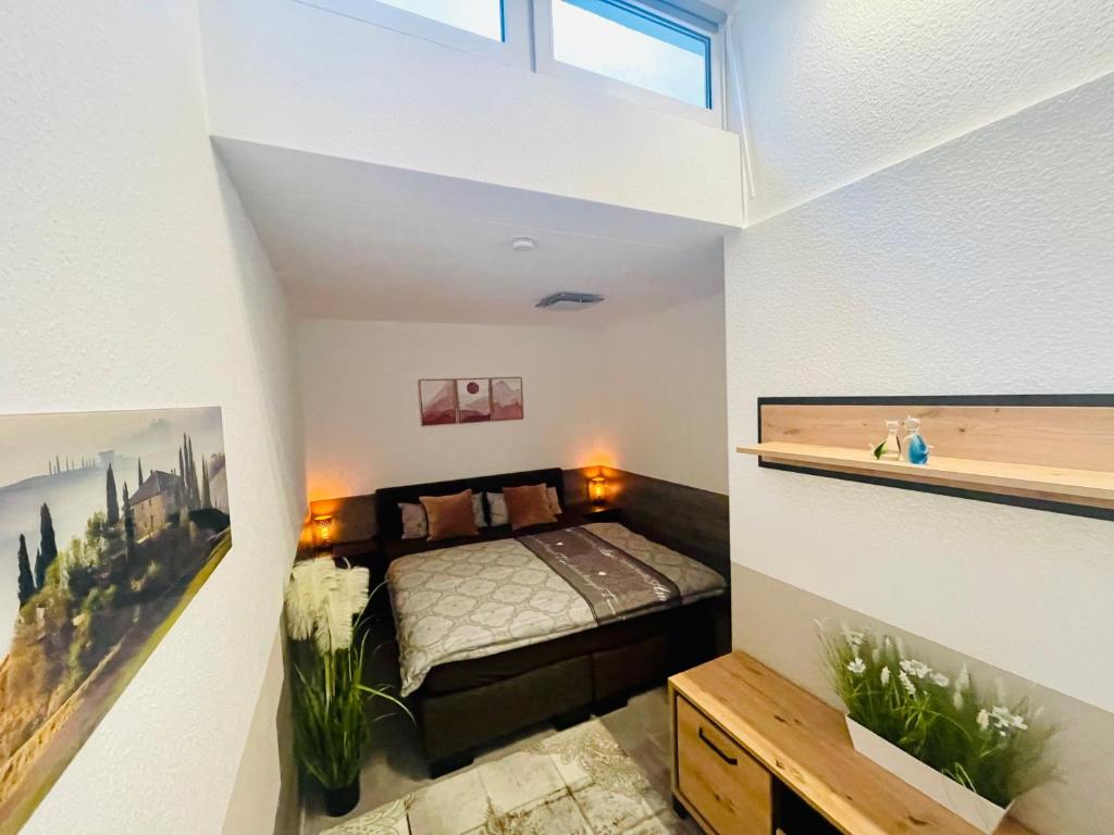 ein kleines Schlafzimmer mit einem Bett und einem Fenster in der Unterkunft 2 Room Galerie Einliegerwohnung in Rheinstetten, Messe Nähe, Rollstuhlfahrer geeignet in Rheinstetten