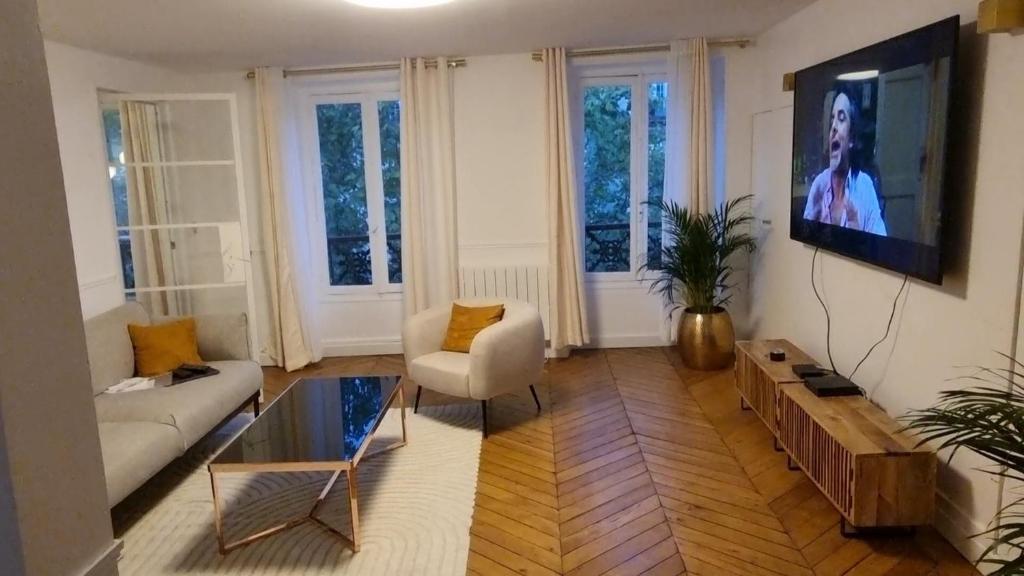 een woonkamer met een bank en een tv bij Champs Elysées Luxury appartment in Parijs