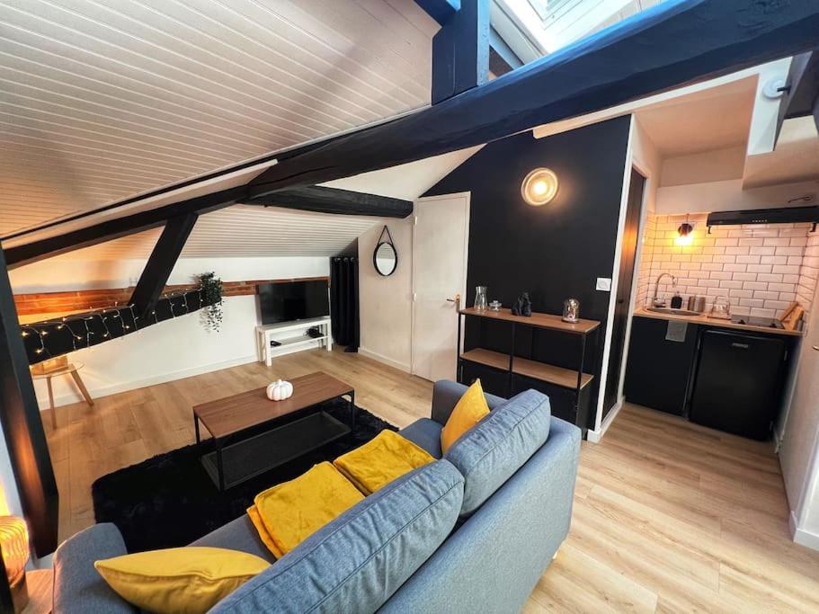 - un salon avec un canapé bleu et des oreillers jaunes dans l'établissement Le Germinal - Studio climatisé calme proche du métro, à Toulouse