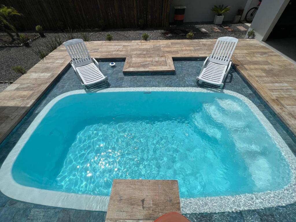 a swimming pool with two chairs and a swimming pool at Residencial Manauara Torres in Torres