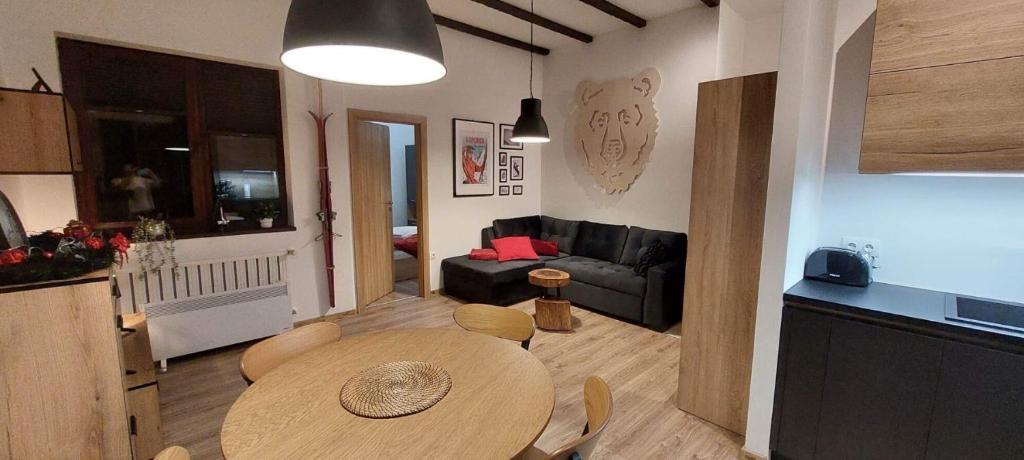 a kitchen and a living room with a table and a couch at Borovets Holiday Homes in Borovets