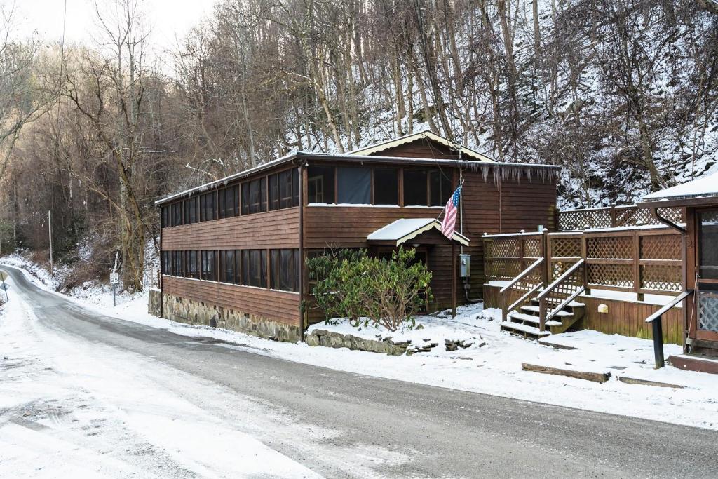 een huis aan de kant van een besneeuwde weg bij River Front Resort in Elkins