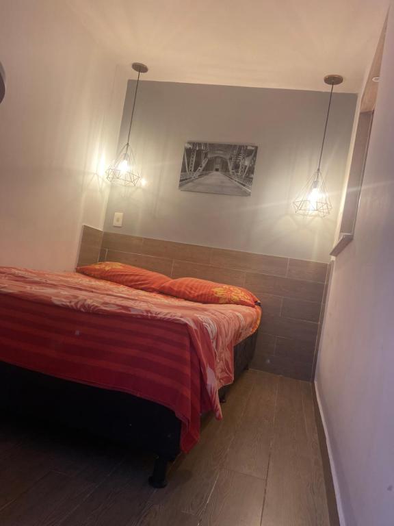 Un dormitorio con una cama con dos luces. en Para groupos y familia grande los molinos laurles, en Medellín