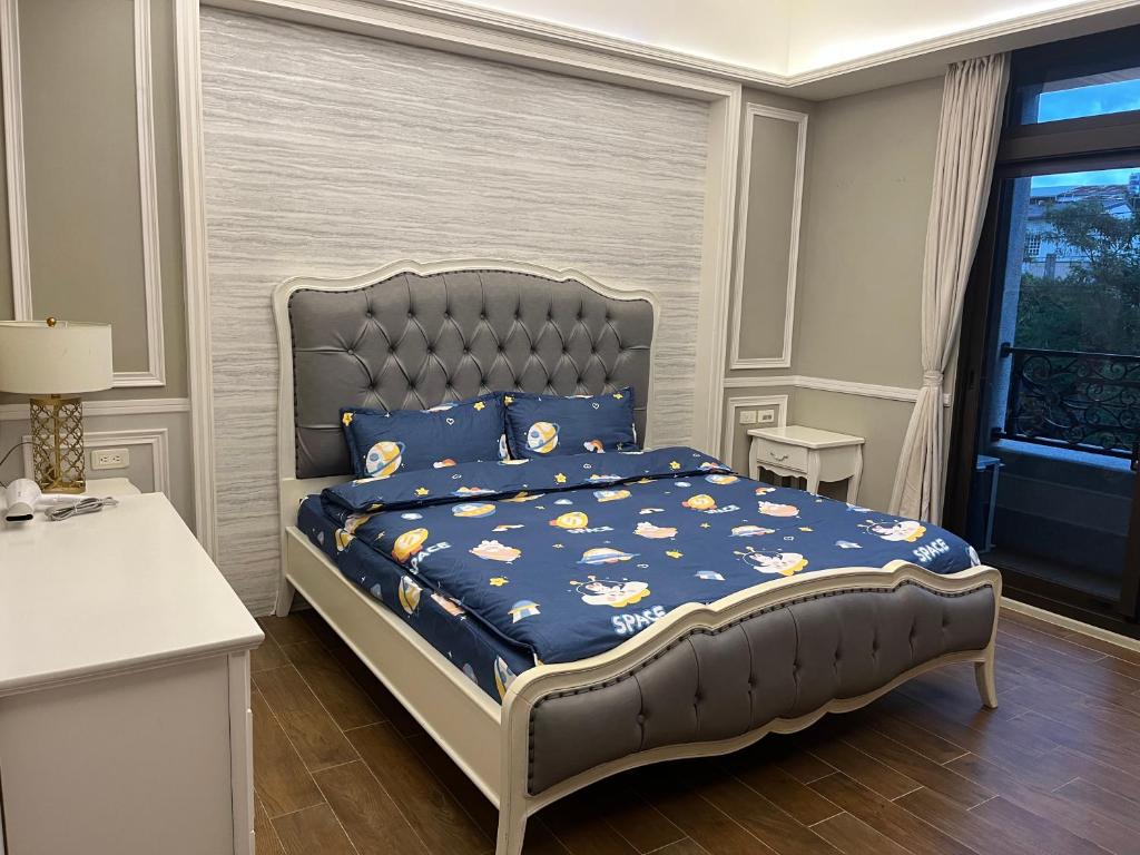 sypialnia z łóżkiem z niebieską kołdrą w obiekcie An Egg Homestay w mieście Beipu