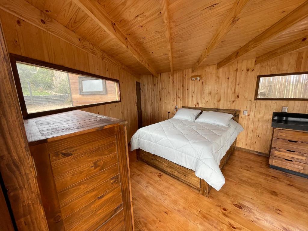a bedroom with a bed in a wooden cabin at Casa al mare uno - Matanzas y Pupuya in Navidad