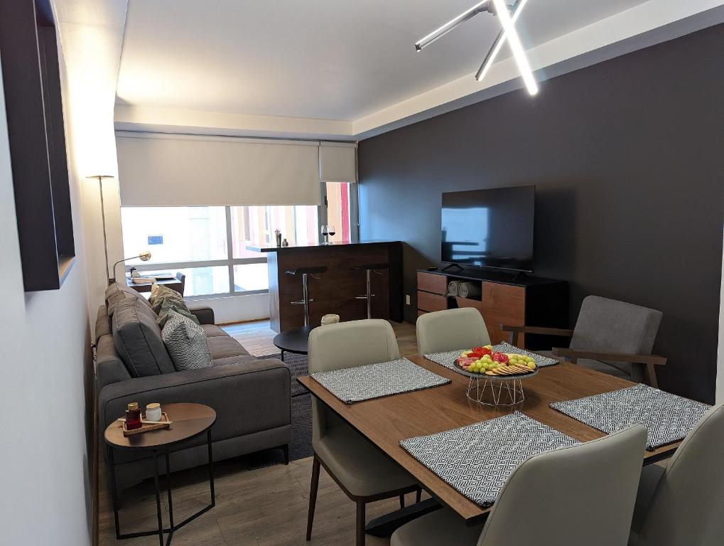 uma sala de estar com uma mesa e um sofá em Luxury Condo Santa Fe Cosmocrat By Bamboo Skylife em Cidade do México