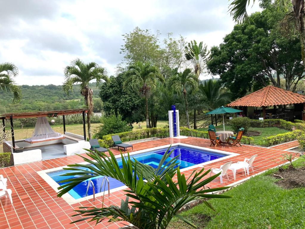 een zwembad in een tuin met een tafel en stoelen bij Hacienda Daniela 