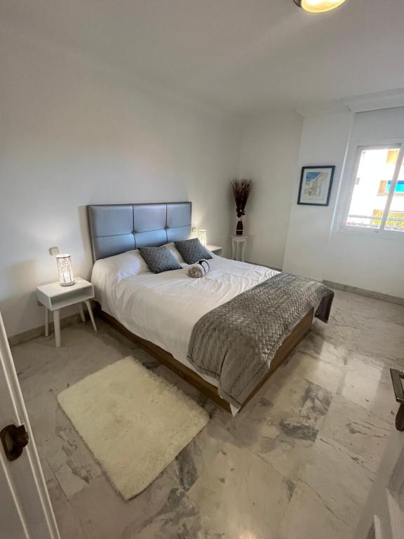 1 dormitorio con 1 cama grande y cabecero azul en Heart of Puerto Banus newly renavated Free parking , WIFi ,Pool,Gym,Padel court, en Marbella