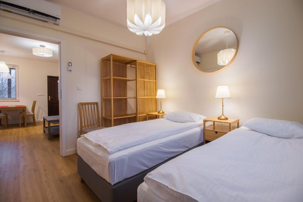 Pokój hotelowy z 2 łóżkami i lustrem w obiekcie Wiśniowy Sad - Domki w Białowieży