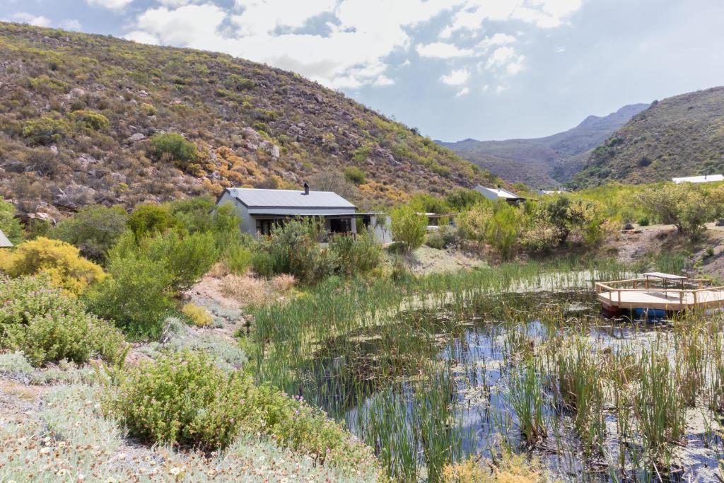 ein Haus inmitten eines Flusses mit einem Hügel in der Unterkunft Cederkloof Botanical Retreat in Citrusdal