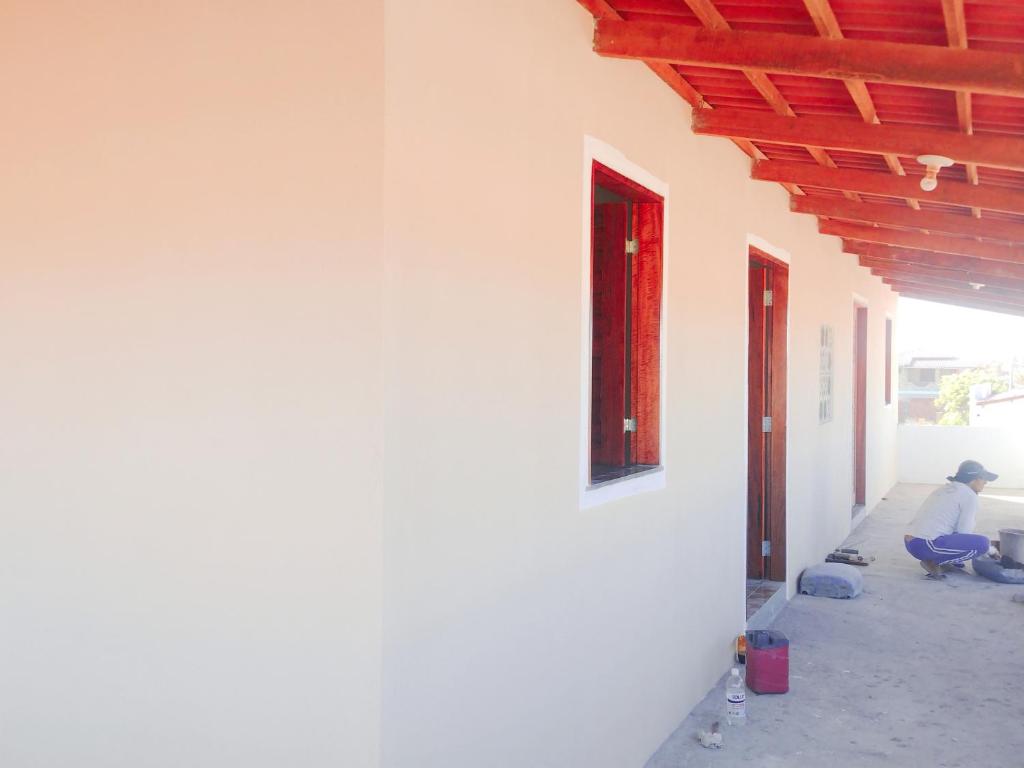 a person sitting on the side of a building at Dunas Mar em Guajiru in Trairi