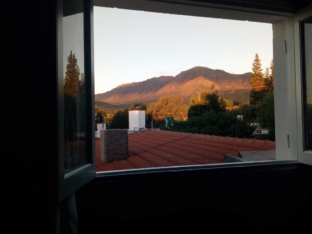 une fenêtre ouverte avec vue sur la montagne dans l'établissement Lomas del Uritorco - Casa de Alq x Temp, à Capilla del Monte